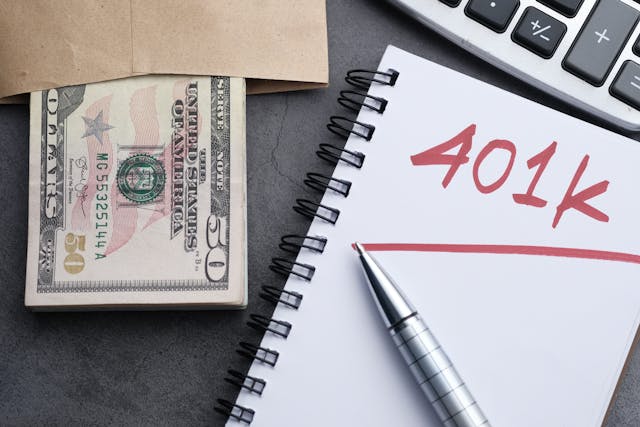 401(k) in notebook next to money