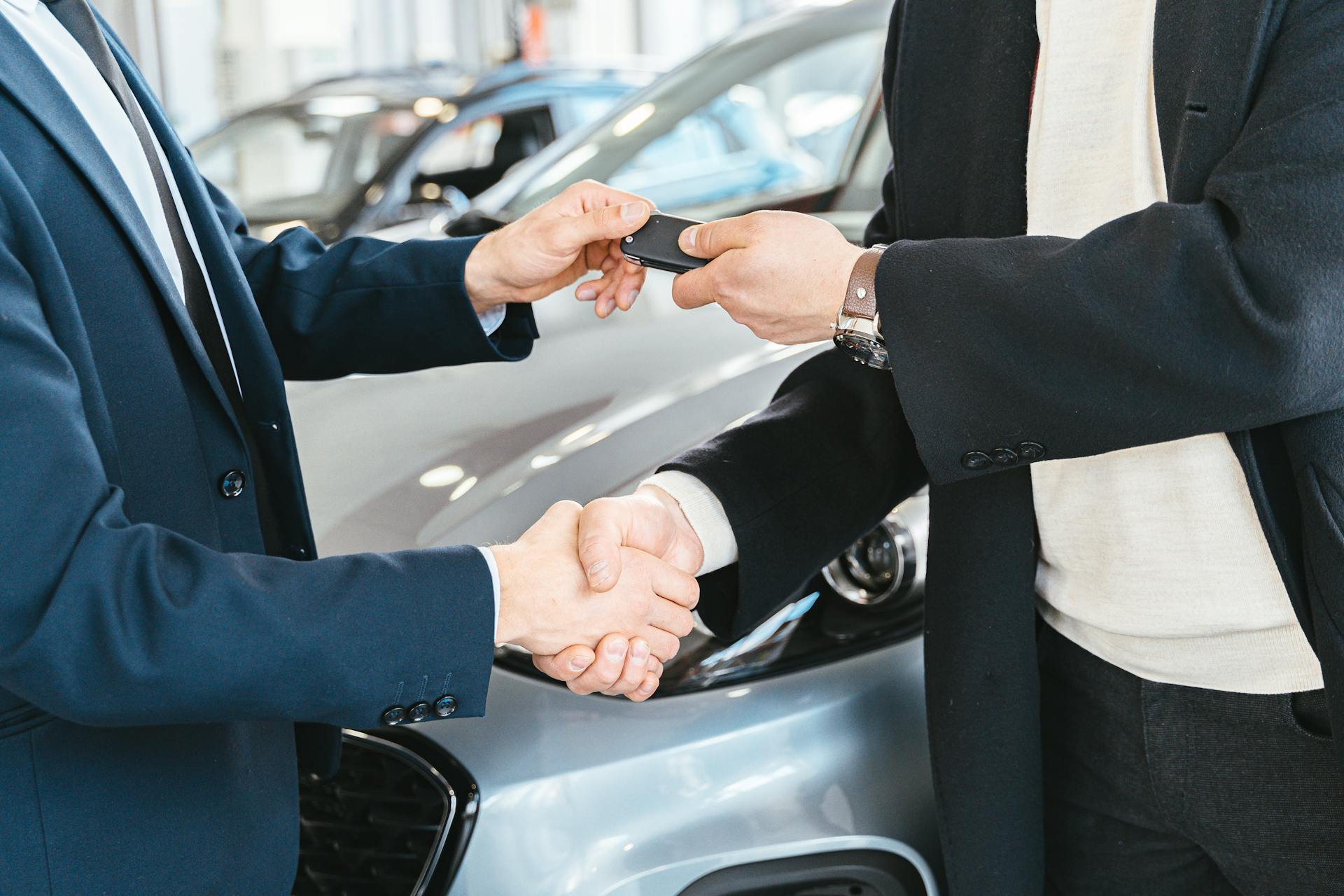 people shaking hands at an auto dealer